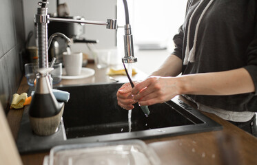 Young woman wash dishes and glass at kitchen