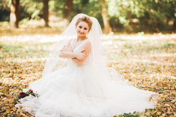 Fototapeta premium Portrait of stunning bride with long hair posing with great bouquet