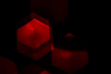 Red hexagonal bokeh lights on dark background from unfocused macro, created with red fairy lights...