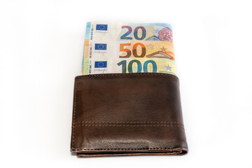 Top view of brown genuine leather wallet with banknotes inside isolated on white background.