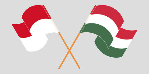 Crossed and waving flags of Indonesia and Hungary