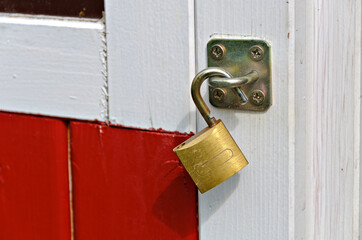 Padlock on a white and red painted wooden door