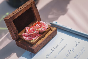 Two gold wedding rings in a beautiful wooden casket with green moss. Wedding accessories. Bride morning