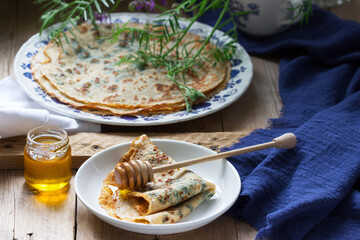 Nettle and spinach pancakes served with honey and coffee. Rustic style.