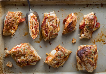 A top down view of slices of Stromboli on a stone pan fresh out of the oven.