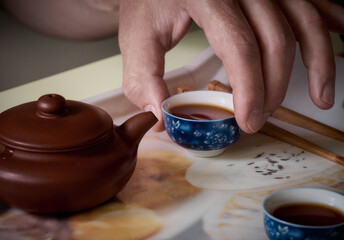 Fototapeta na wymiar Pouring tea from teapot into cups.