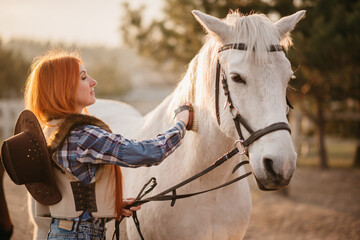 Obraz premium Young woman farmer combing a horse at the ranch. Close-up.