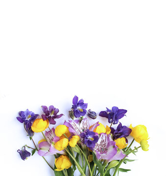 Bright spring flower arrangement. Lilac Alstroemeria and Aquilegia and yellow flowers of trolius europaeus on a white background. Bright light colors. Background for spring greeting cards, invitations
