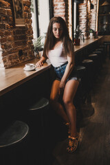 Fototapeta na wymiar Beautiful woman posing for the camera sitting in a cafe.