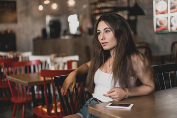 Beautiful woman posing for the camera sitting in a cafe.