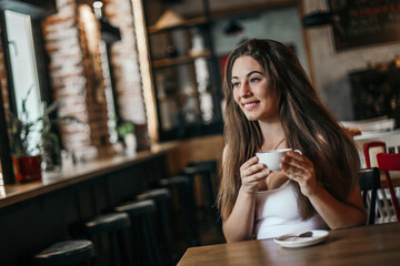 Beautiful woman drinking coffee sitting in a cafe.