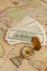 Compass with a bundle of big money are on the map
