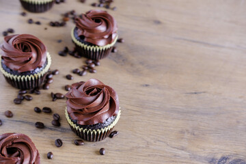 Dark chocolate coffee cupcakes on wooden brown table background. Sweet food concept. 