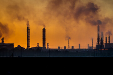 production pipes with smoke at sunset