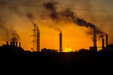 production pipes with smoke at sunset