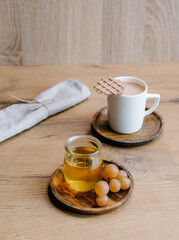 Healthy snack set with muscat grapes, honey and coffee with waffles on wooden background. 
