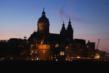 Fototapeta na wymiar The Basilica of Saint Nicholas illuminated at sunset , Amsterdam city, the most touristic city of netherlands.