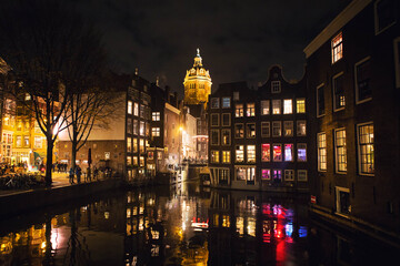 Fototapeta na wymiar Night view of Amsterdam city with canal and Basilica of Saint Nicholas, famous landmark view from the Armbrug bridge, Netherlands, Holland, Europe.