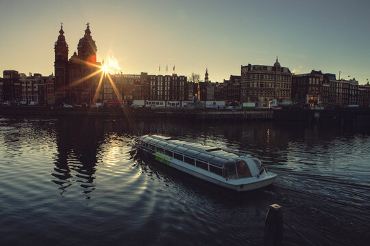 Sunrays throught the  the The Basilica of Saint Nicholas, unmistakable shape of the skyline of Amsterdam city, Netherlands, Holland, Europe.