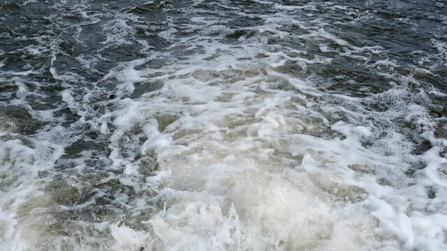 Rushing water in a mountain shallow river in slow motion video