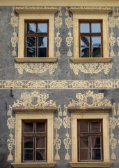 Fototapeta na wymiar Vintage style old wooden windows with ornaments on the wall.Exterior of a building.