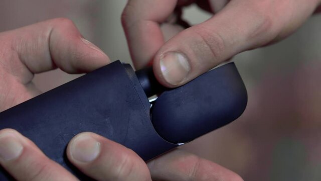 The hand opens the charging case of the electronic cigarette, and takes out the cigarette holder