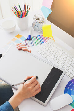 Young Handsome Graphic designer using graphics tablet to do his work at desk