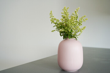 Soft home decor. Small white flowers in ceramic vases on table top. Front view composition with a space for a text. Eco decor
