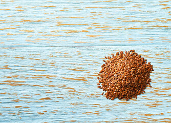flax seeds  on a blue wooden background, top view.