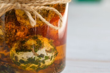 Labne balls with herbs and spices in a glass jar. Traditional yogurt cream cheese in the Middle East. Close-up.
