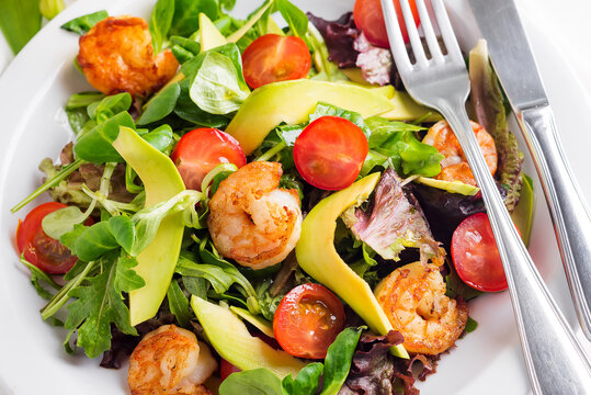 Avocado shrimp salad with cherry tomatoes and latuce salad on a plate