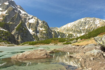 Poland Tatra Mountains (Czarny Staw pod Rysami). View of the pond in the Tatra Mountains. Descending ice from the spring lake in the Tatra Mountains.