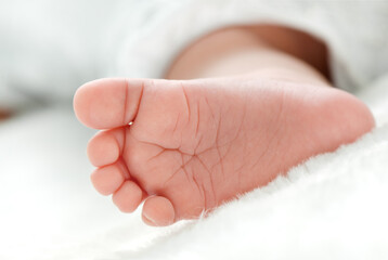 Newborn baby's foot  on white blanket