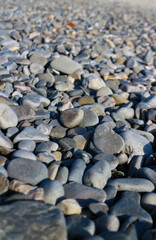 Stones background - closeup of pebbles with selective focus, seen on the famous Pebble Beaches of Nice on the French Riviera, France. 