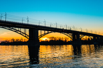 Plakat Silhouette of a bridge over a river at sunny sunset