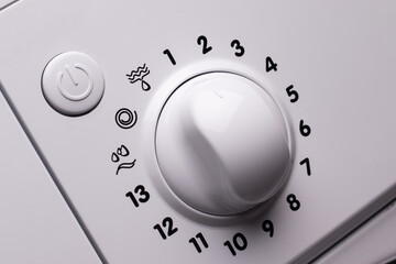 Washing machine control panel. Round knob for choosing the washing mode and power button.