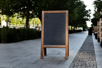 Empty wooden chalkboard stand on a street ready to be filled