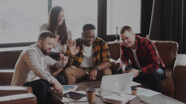 business, online communication and technology concept - happy creative internationa team having video conference or interview at office and waving hands