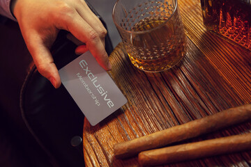 Man's hand puts exclusive membership card on the table. Gentleman's hand puts exclusive membership...