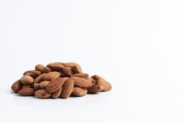 handful of almonds on a white background. close up raw nuts. healthy food. vegan food. copy space for text