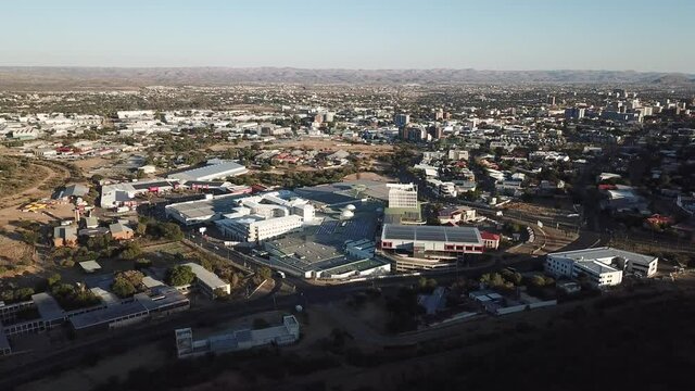 4K aerial video of Windhoek capital central store district, Maerua Mall shopping center on bright sunrise morning in Khomas Region, central Namibia
