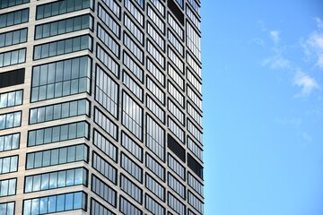 Fototapeta premium Facade texture of a glass mirrored office building. Fragment of the facade. Modern architecture of the office building.