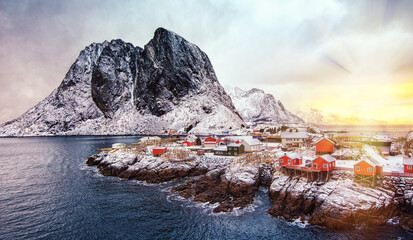 Hamnoy - Lofoten Island, Norway. Red Rorbuer houses Northern Norway. Snowy landscape. Scenic view at sunrise.