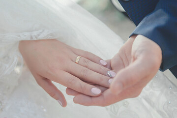 Obraz na płótnie Canvas bride and groom tenderly hold hands on a wedding walk