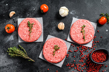 Burger patties, raw fresh ground, mince meat. Black background. Top view
