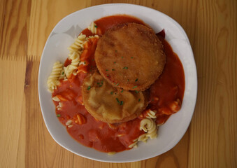 Original German Democratic Republic version of escalope chasseur with breaded Jagdwurst, noodles and tomato sauce                               