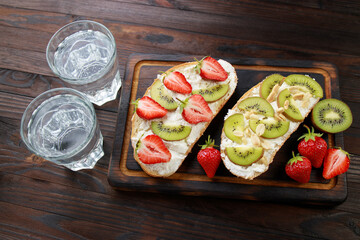 Fruit toasts with kiwi, strawberry and ricotta. Healthy and delicious homemade snacks. Proper nutrition, balanced food