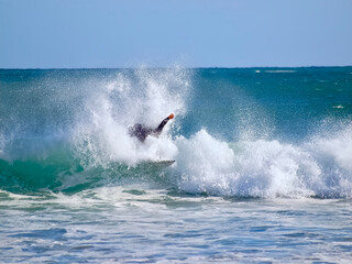 Surfer on his board sporting in the ocean