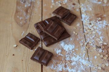 Several pieces of the  milk chocolate, oat flakes and flour