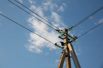 Power pole with electrical insulators against the sky